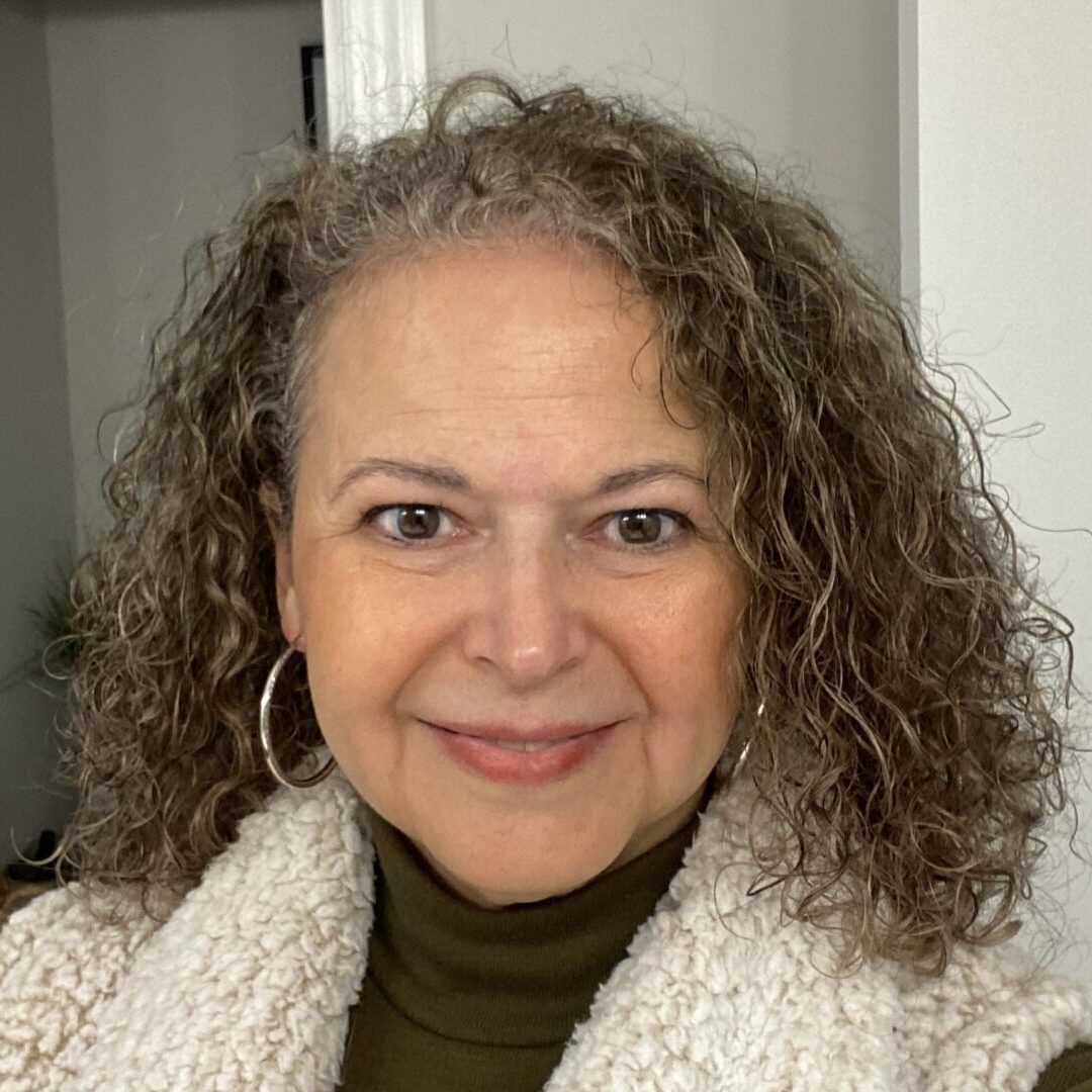 Smiling woman with curly gray hair