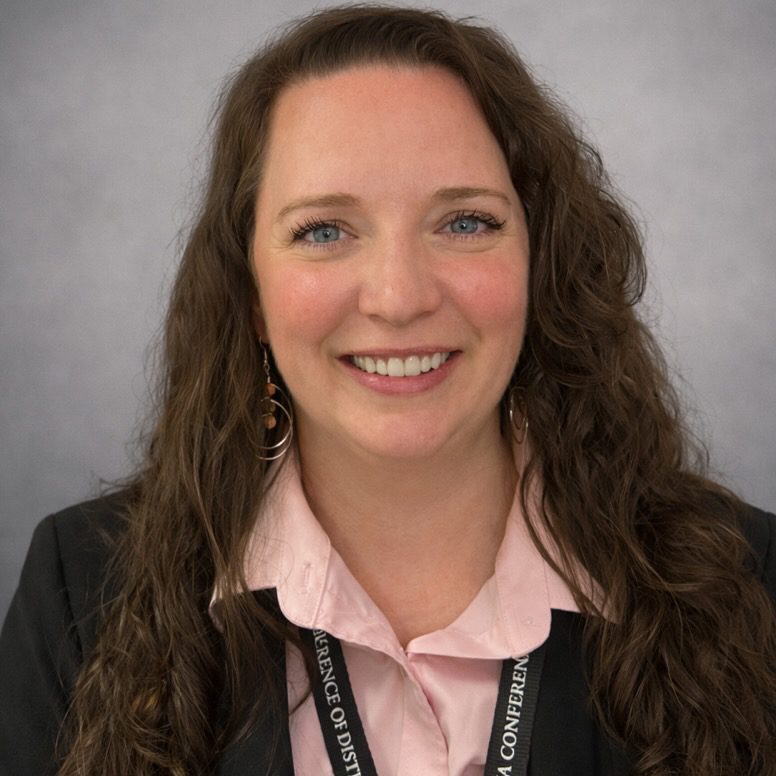 Smiling professional woman headshot with lanyard